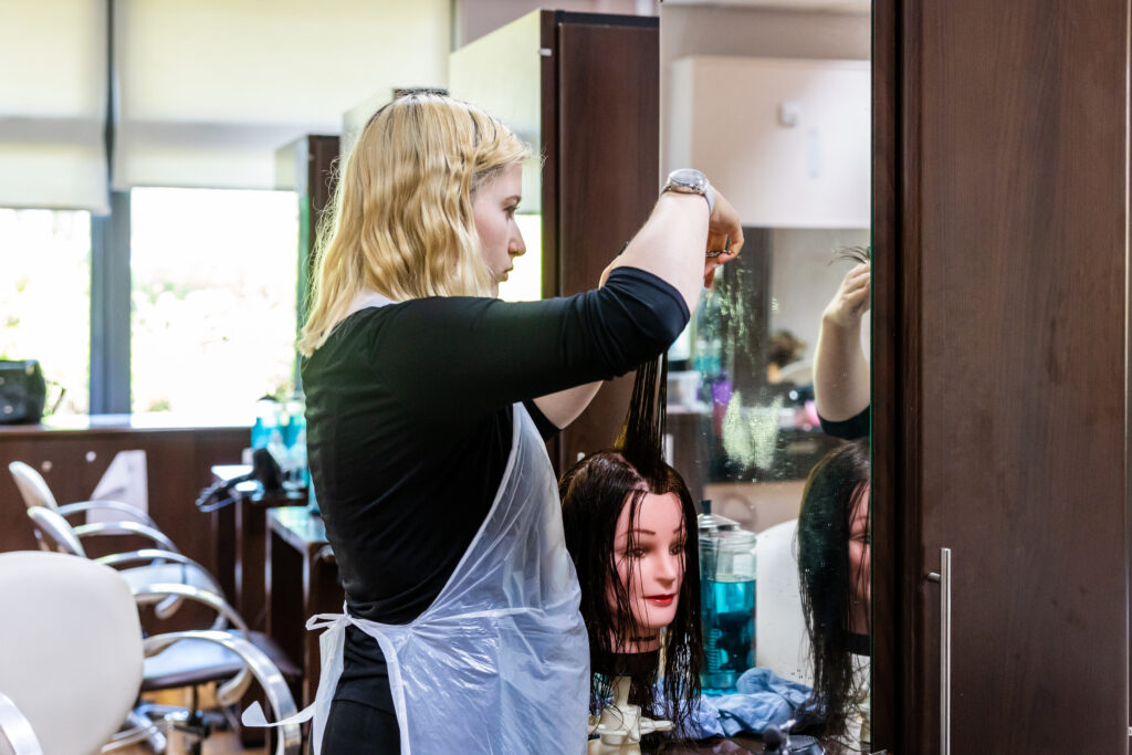 Hairdressing student cutting a mannequins hair.