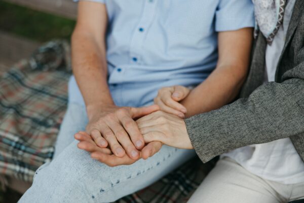 Younge person holding an elderly persons hand