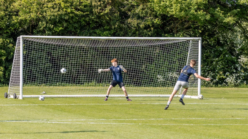 Sports students playing football on the college field.