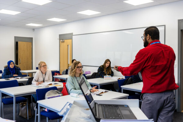 Adults learning in a classroom at mk college