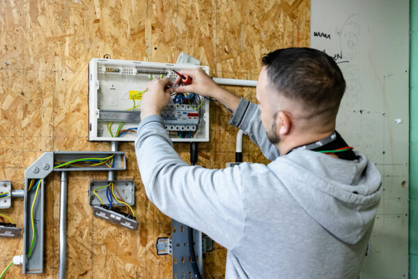 Students wiring an electrical appliance that is attached to a board of MDF