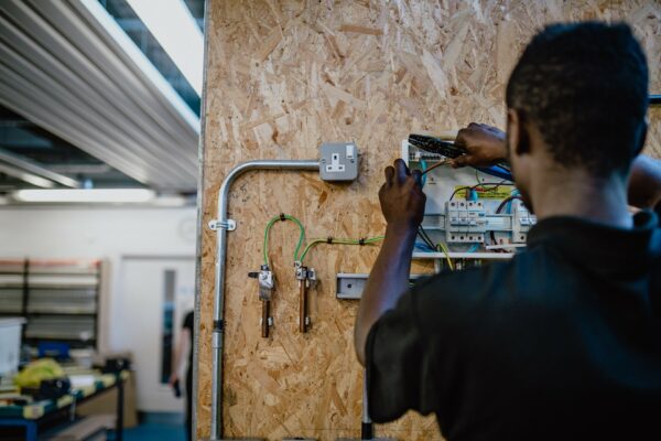 Students wiring an electrical appliance that is attached to a board of MDF