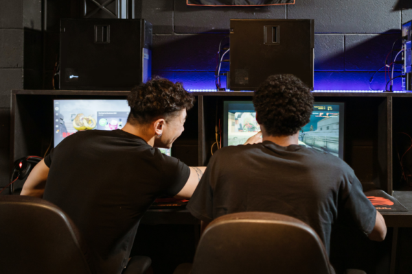 2 males games and animation students sat behind computers working