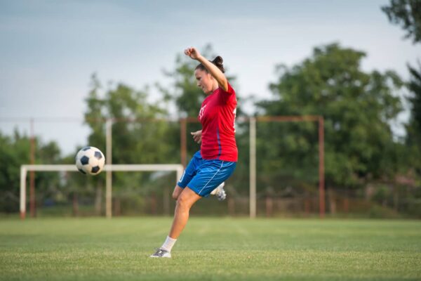 Female student kicking a football