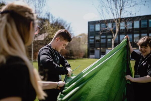 Public services students putting together a green tent.