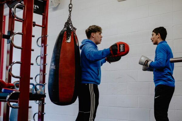 Students in the gym using boxing gloves and mittens