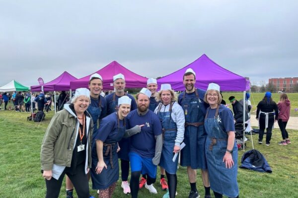 MK College Group CEO Sally Alexander with colleagues from MK College Group in chefs' hats and running gear, at the annual Pancake Race in Campbell Park in Milton Keynes.