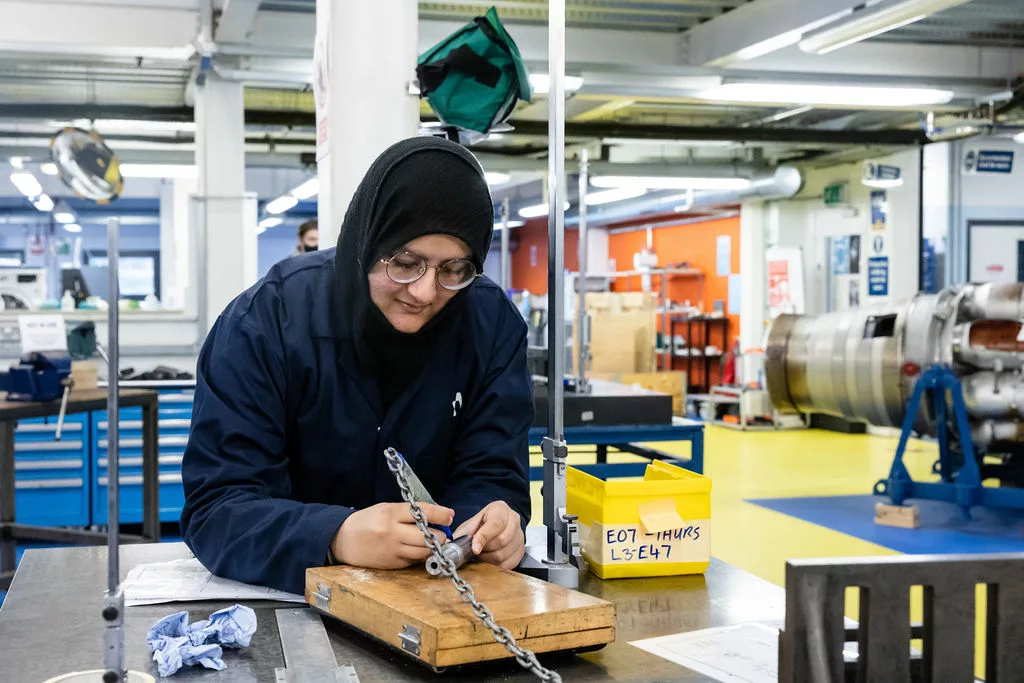 Carpentry student using tools within the workshop to make something