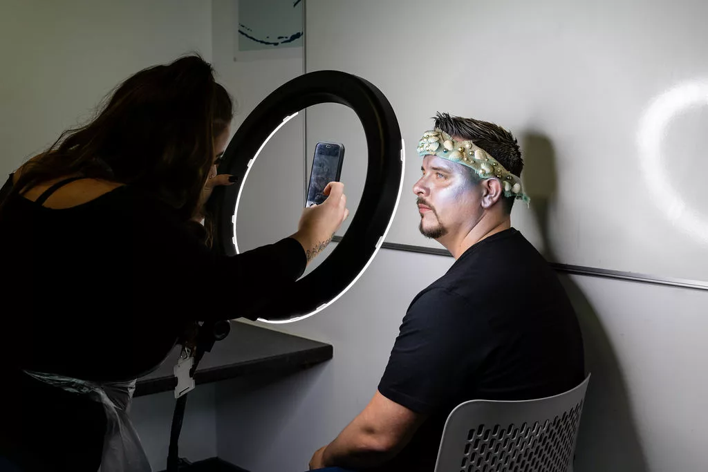 Makeup student taking a photo of their work.