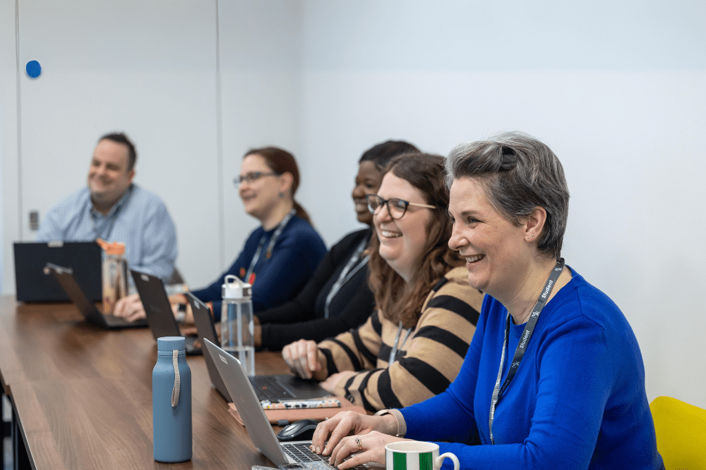 Group of students working in the classroom on laptops