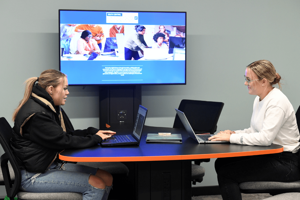 2 female students working at the IoT on their laptops