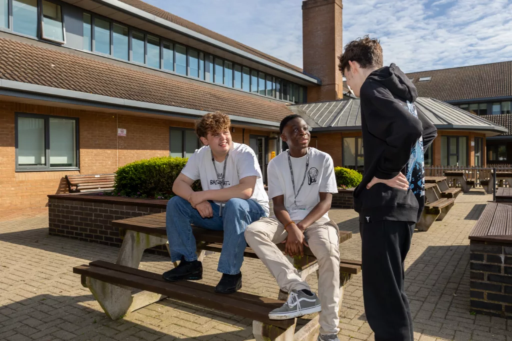 Students engaging in a discussion while seated outdoors.