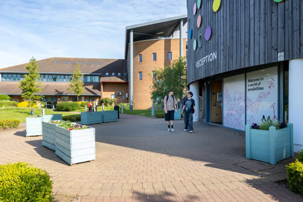 Students walking along a well-maintained pathway on campus.