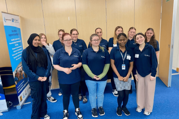 Students from MK College stood in two rows smiling at camera. Students are taking part in a care competition hosted by PJ Care.
