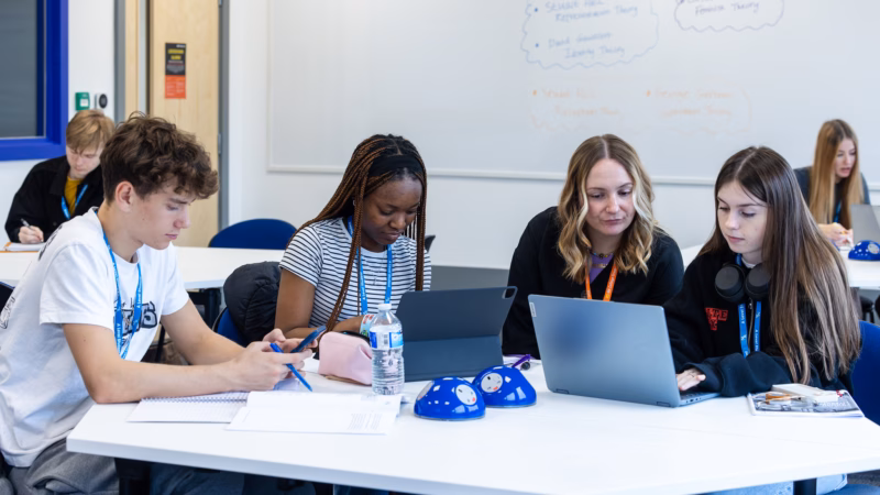 A Level students working on laptops in a classroom.