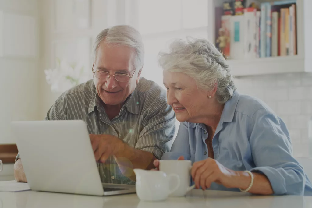 Elderly couple looking at a laptop screen together