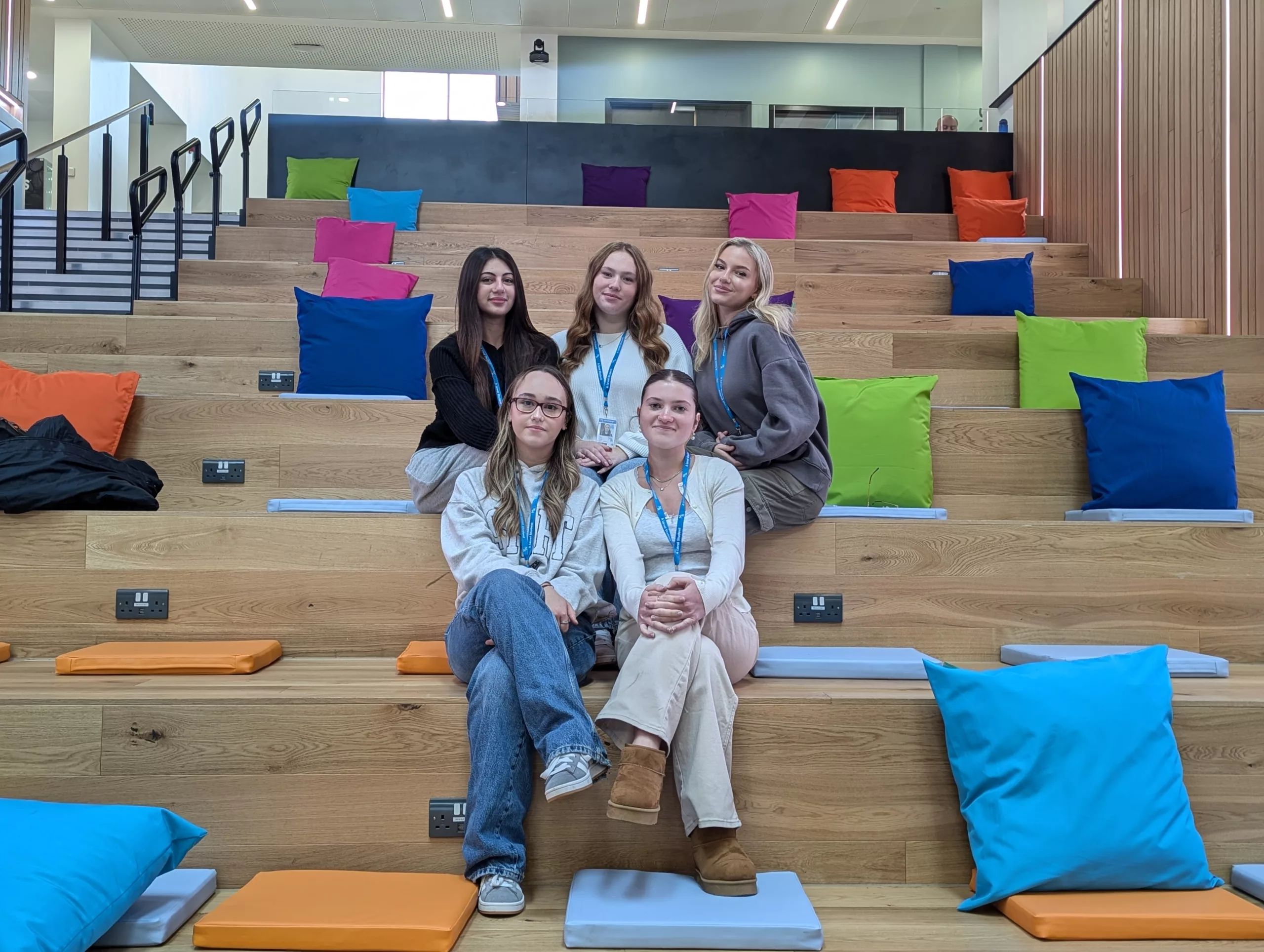 Five A Level students from MK College. The students are sat in two rows on benches at the South Central Institute of Technology.