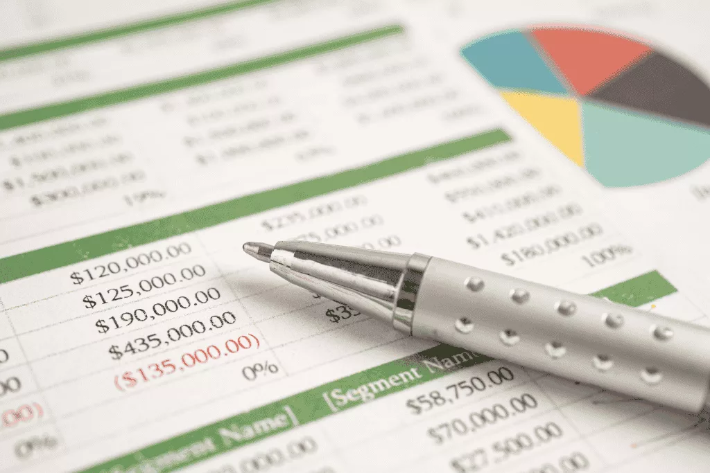 A close-up of a financial spreadsheet with a pen resting on top.