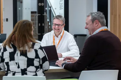 Employers sat talking with laptops