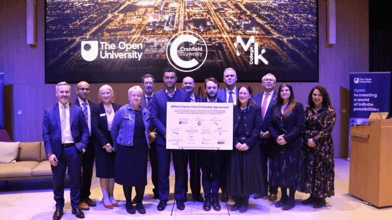 Sally Alexander along with local MPs and representatives of The Open University and Cranfield University. Everyone is standing in a line, with a board in the middle with all of the organisations' logos as part of the University Civic Agreement that was signed at the event.