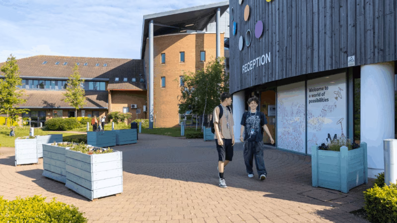 Two MK College students walking outside Chaffron Way campus.